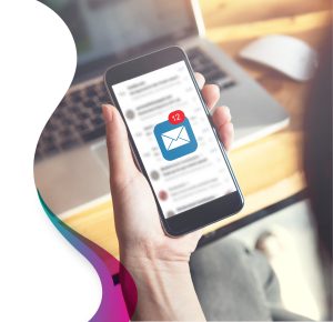 Person holding smartphone with email newsletters visible in inbox and new message notification badge