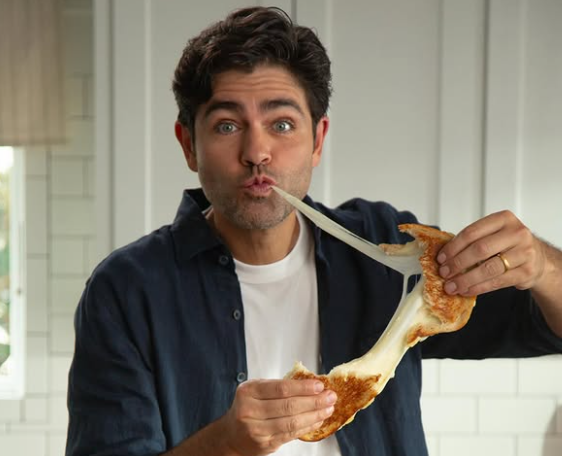 Adrian Grenier holding a grilled cheese sandwich in a Jarlsberg campaign image