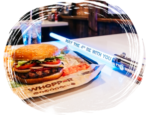 Burger meal with themed lightsaber prop displaying May the 4th message on table